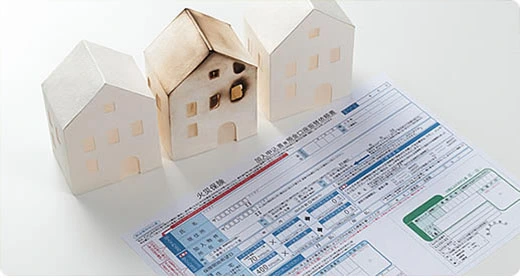 火災保険の書類と住宅の模型
